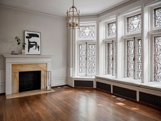 A fireplace with a plant on top of it and a picture beside it.