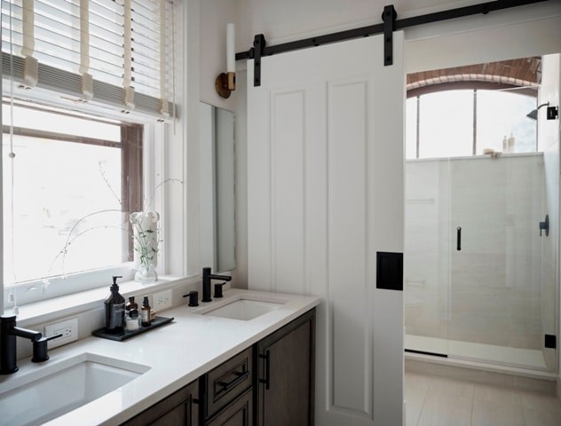 A bathroom with a white sink and a white door.