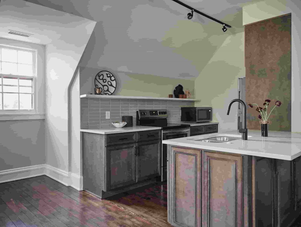 A kitchen with a black oven and a white counter.