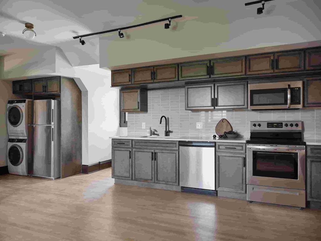 A modern kitchen with stainless steel appliances and wooden cabinets.