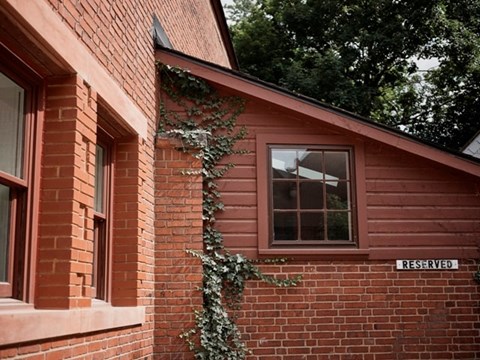 A red brick building with a window and a sign that says "RESERVED".