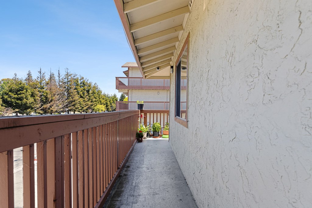 the walkway to the condo is empty and has a balcony