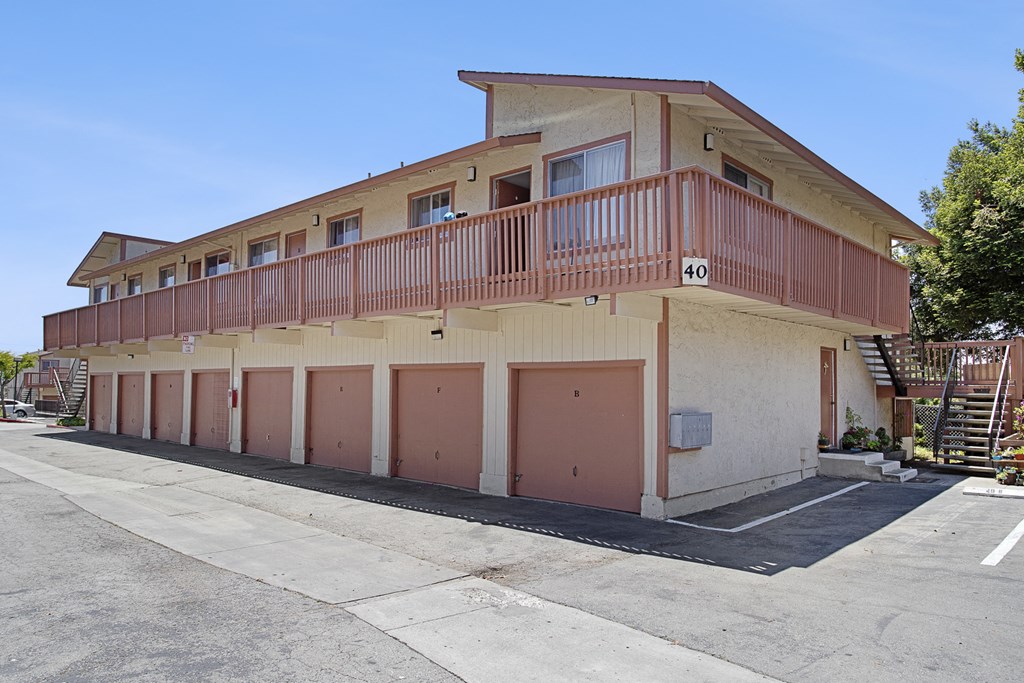 an image of an apartment building with pink doors and balconies
