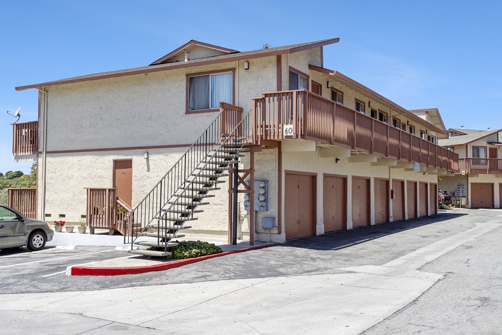 an apartment building with stairs and a red curb