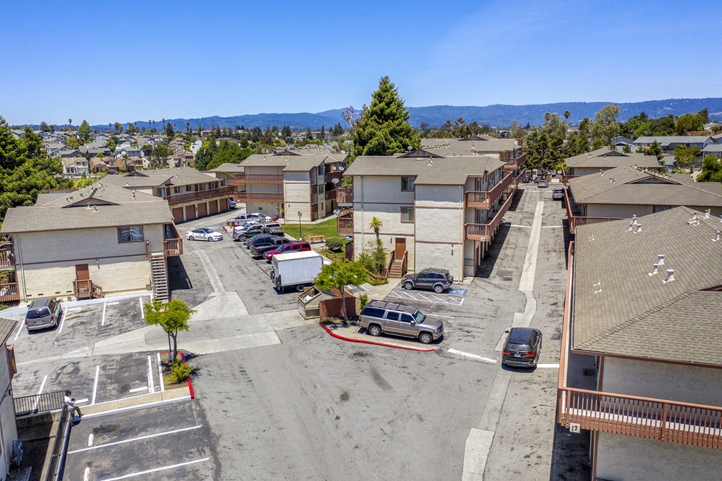 an aerial view of a neighborhood with cars parked in a parking lot