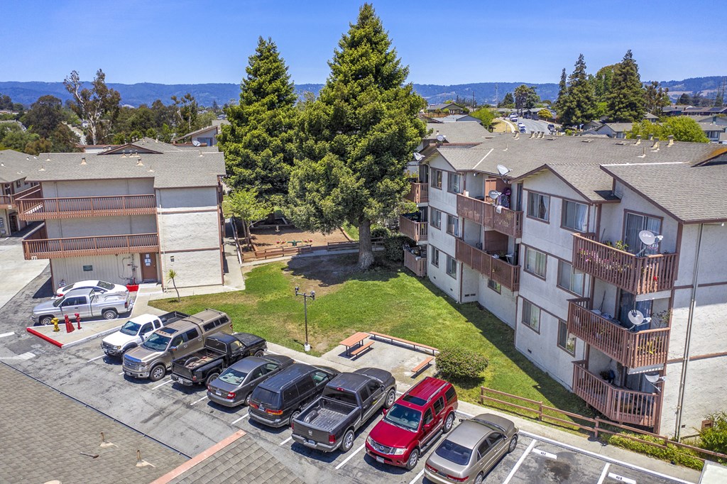 an aerial view of an apartment complex with cars parked in a parking lot
