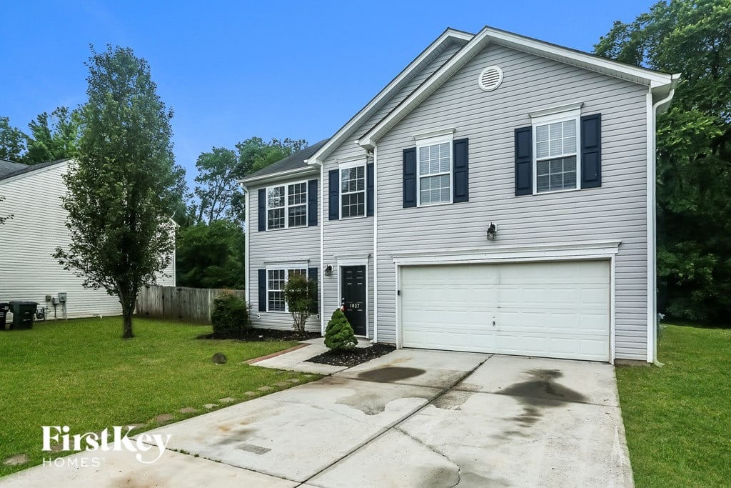 the front of a white house with a white garage door