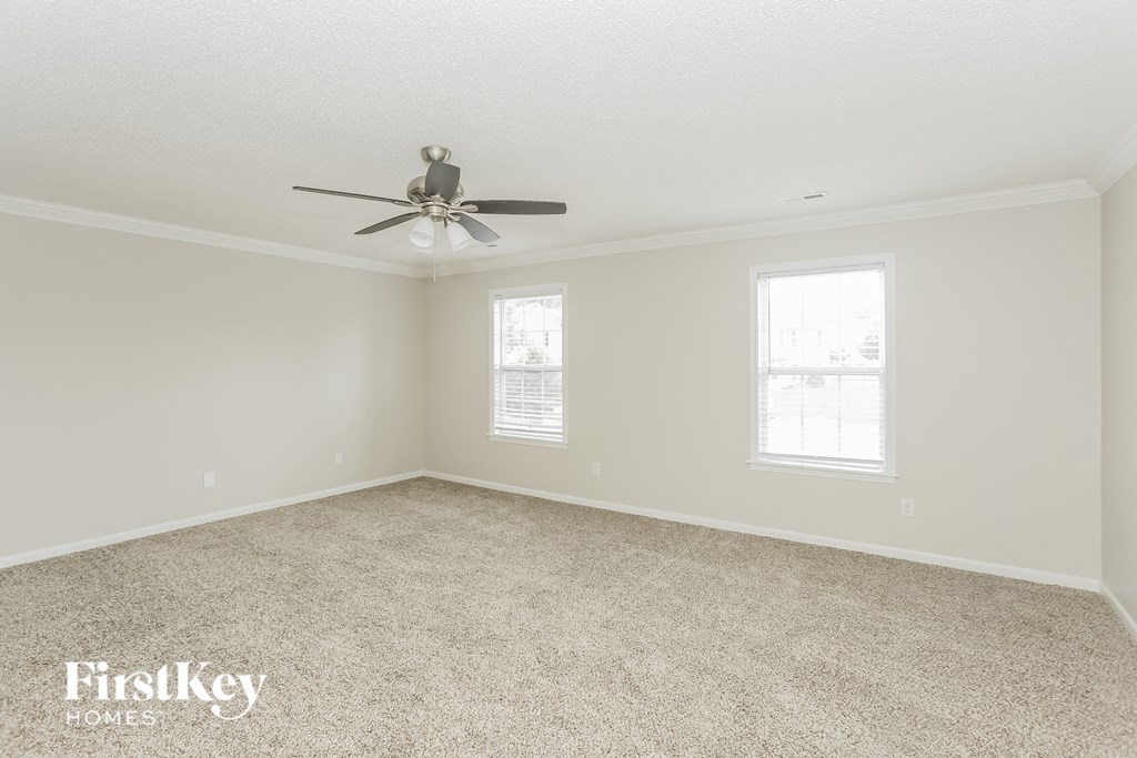 a bedroom with a ceiling fan and a carpeted floor