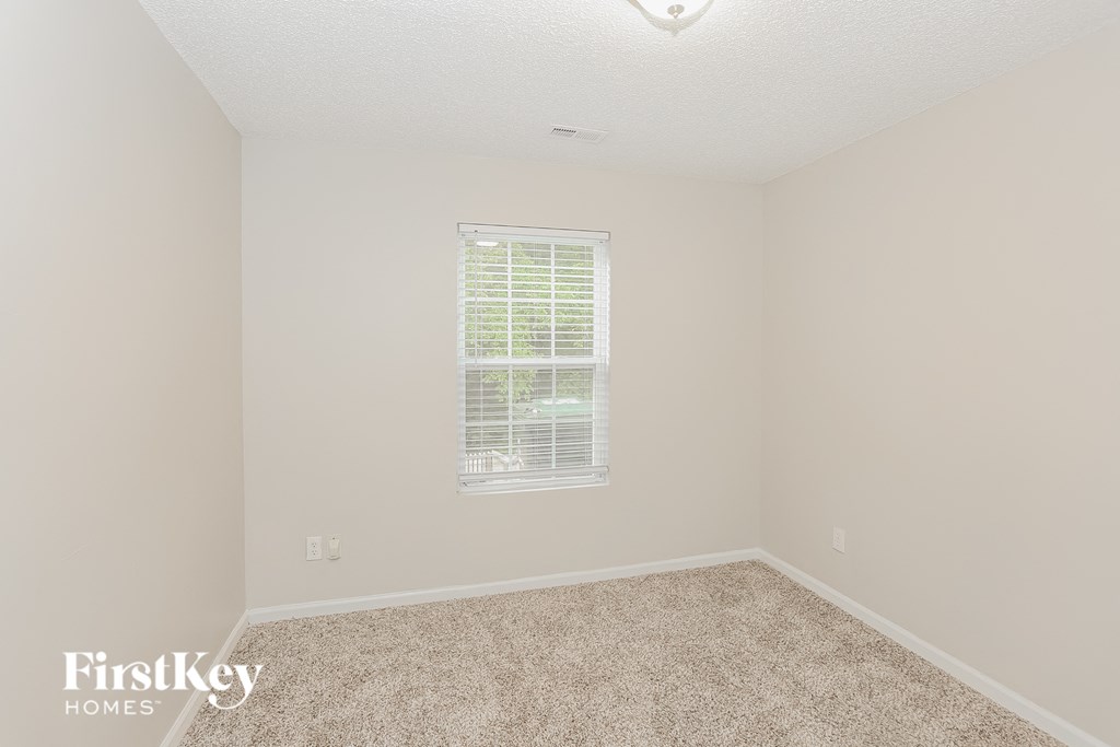 a empty room with carpet and a window