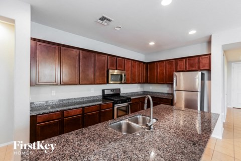 a kitchen with granite counter tops and wooden cabinets