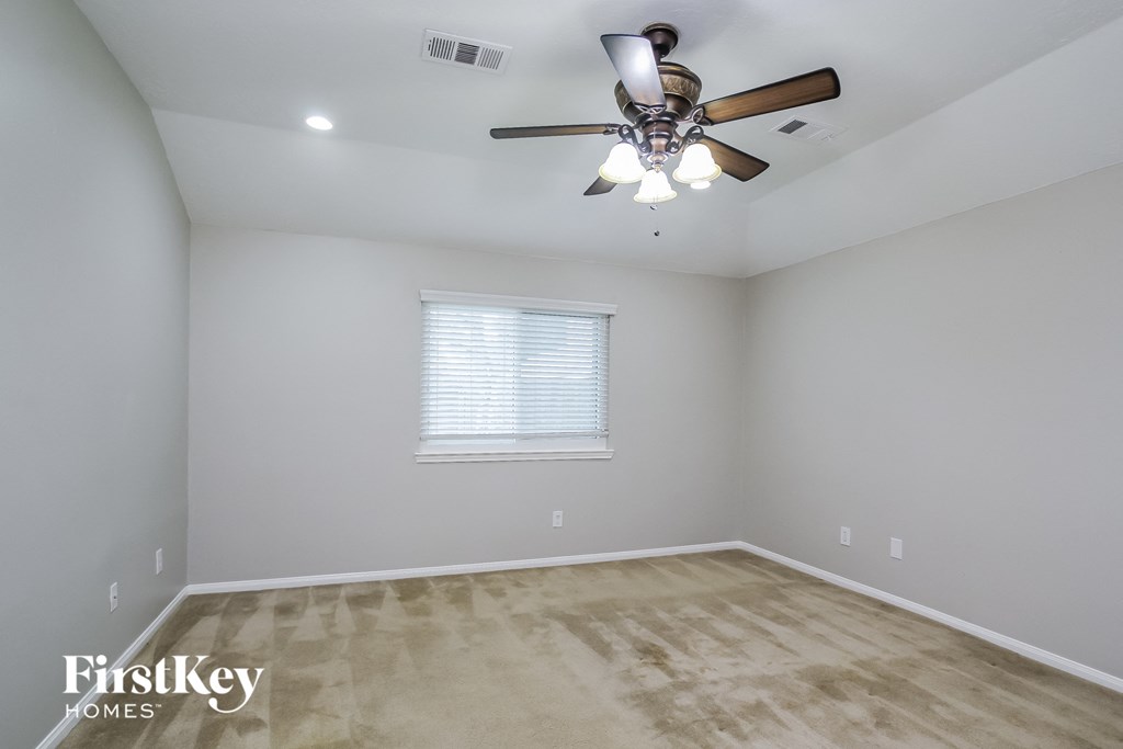 a empty room with a ceiling fan and a window