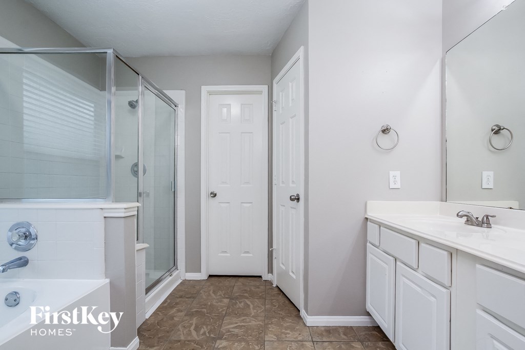 a white bathroom with a large shower and two sinks
