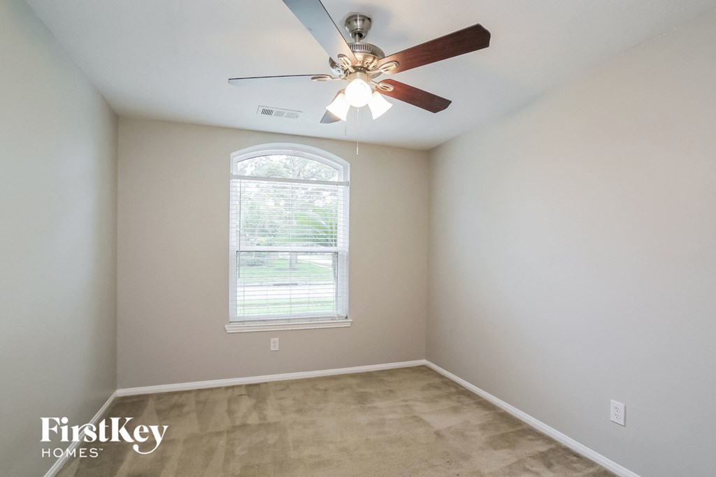 a bedroom with a ceiling fan and a window