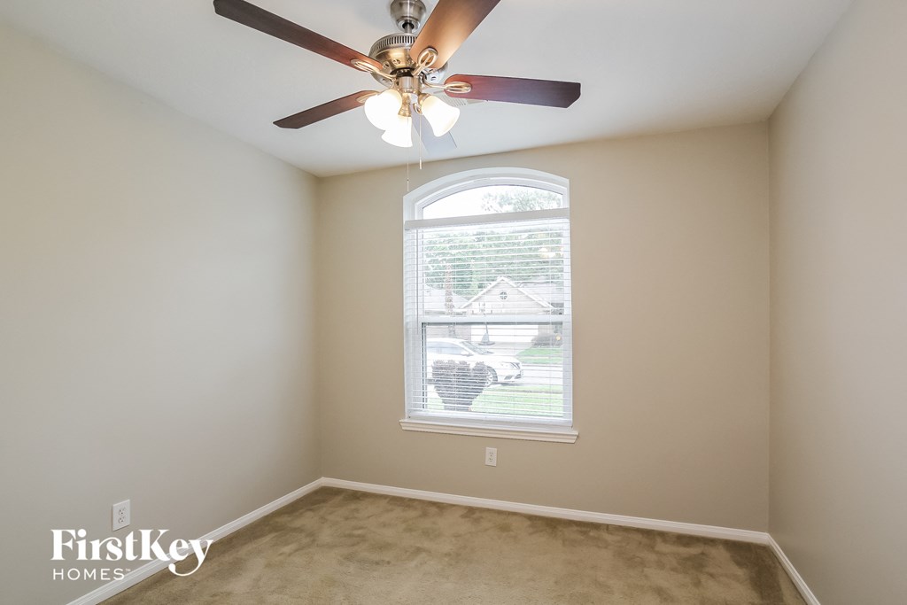 a bedroom with a ceiling fan and a window