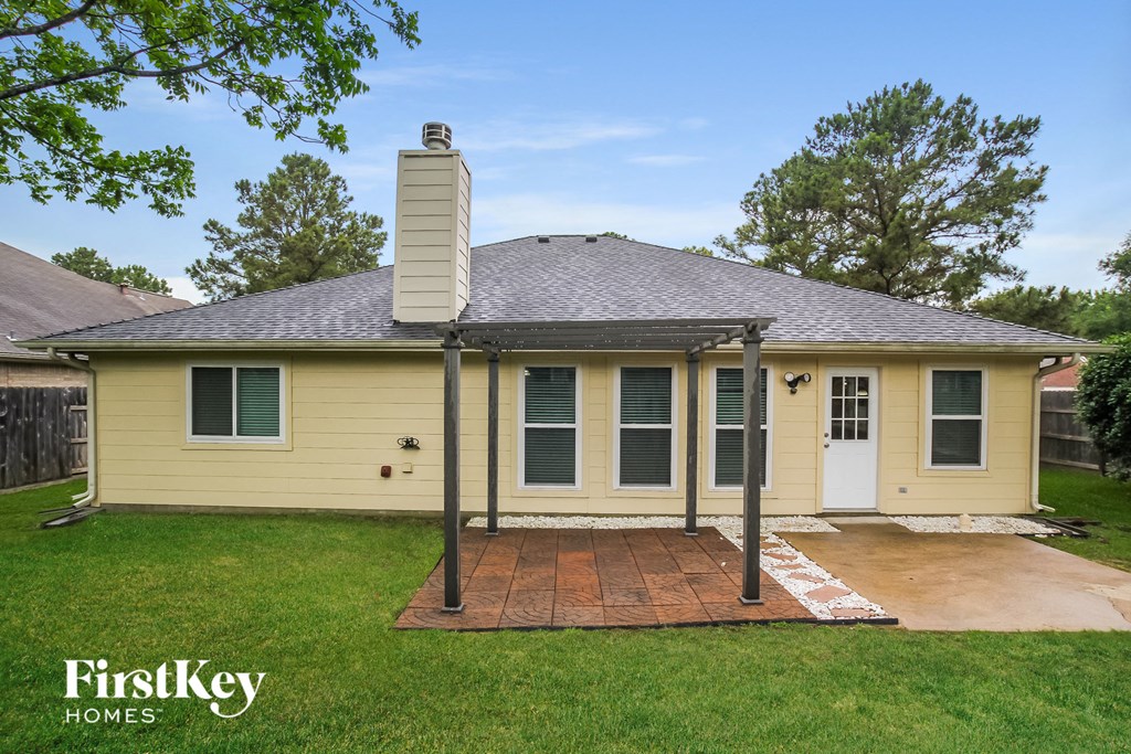 the front of a yellow house with a brick patio