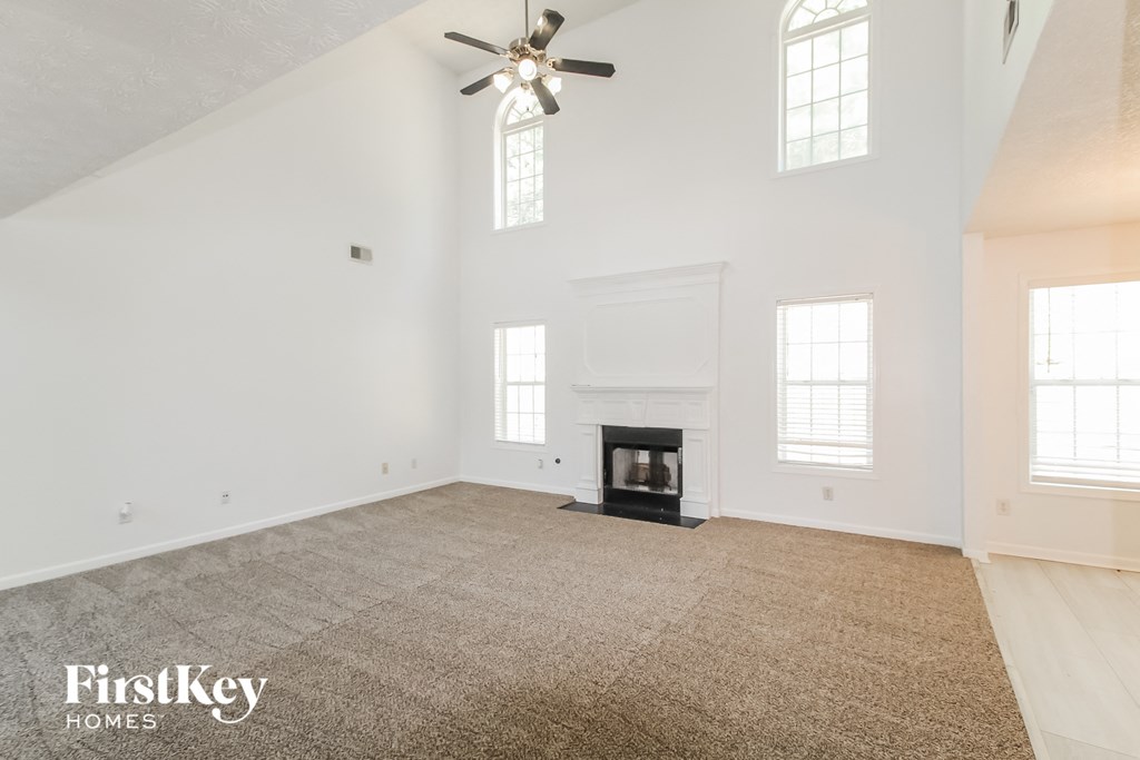 a white room with a fireplace and a ceiling fan
