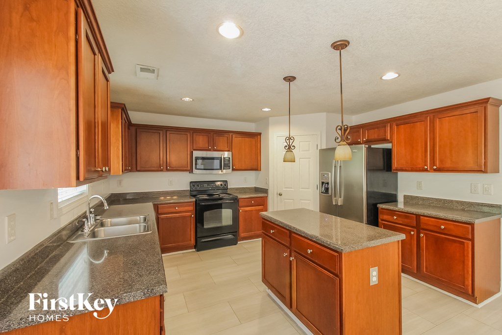a kitchen with wooden cabinets and stainless steel appliances and granite counter tops