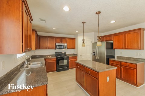 a kitchen with wooden cabinets and stainless steel appliances and granite counter tops