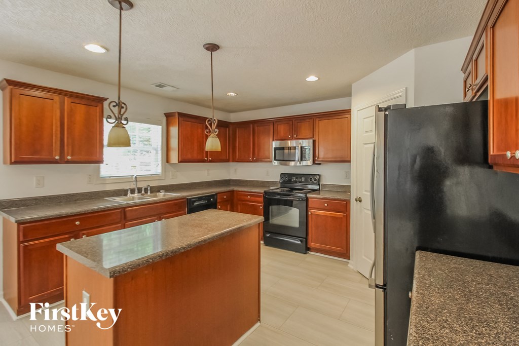 a kitchen with wooden cabinets and a black refrigerator
