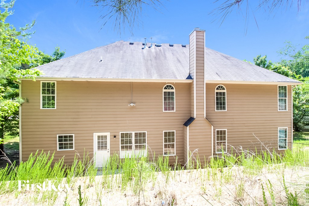 a brown house with tall grass in front of it