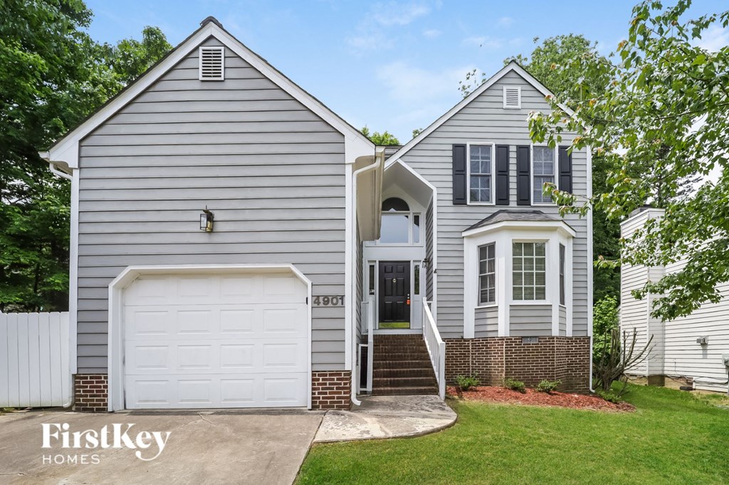 a white and gray house with a white garage door