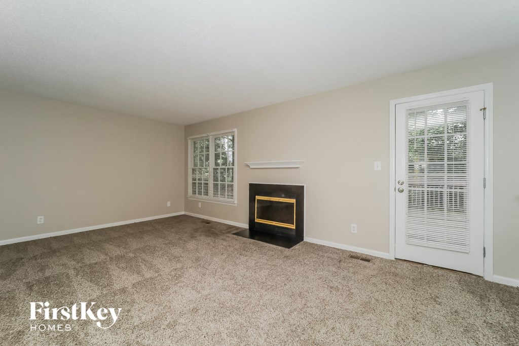 a living room with a fireplace and a white door