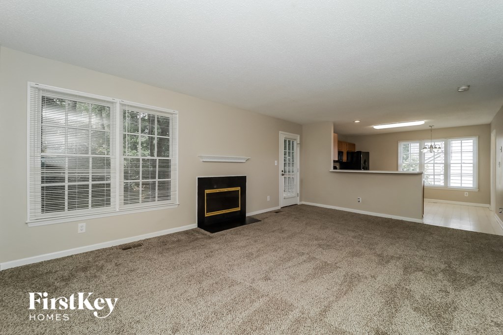 a living room with a fireplace and a carpeted floor