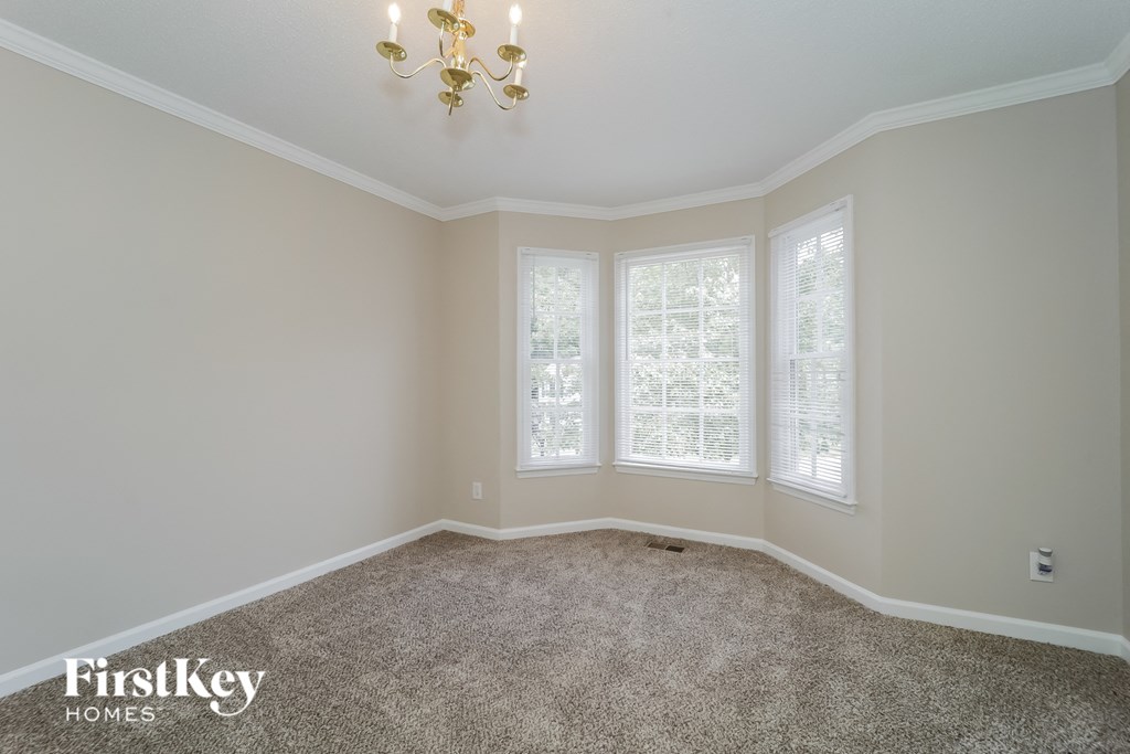 a empty room with three windows and a chandelier