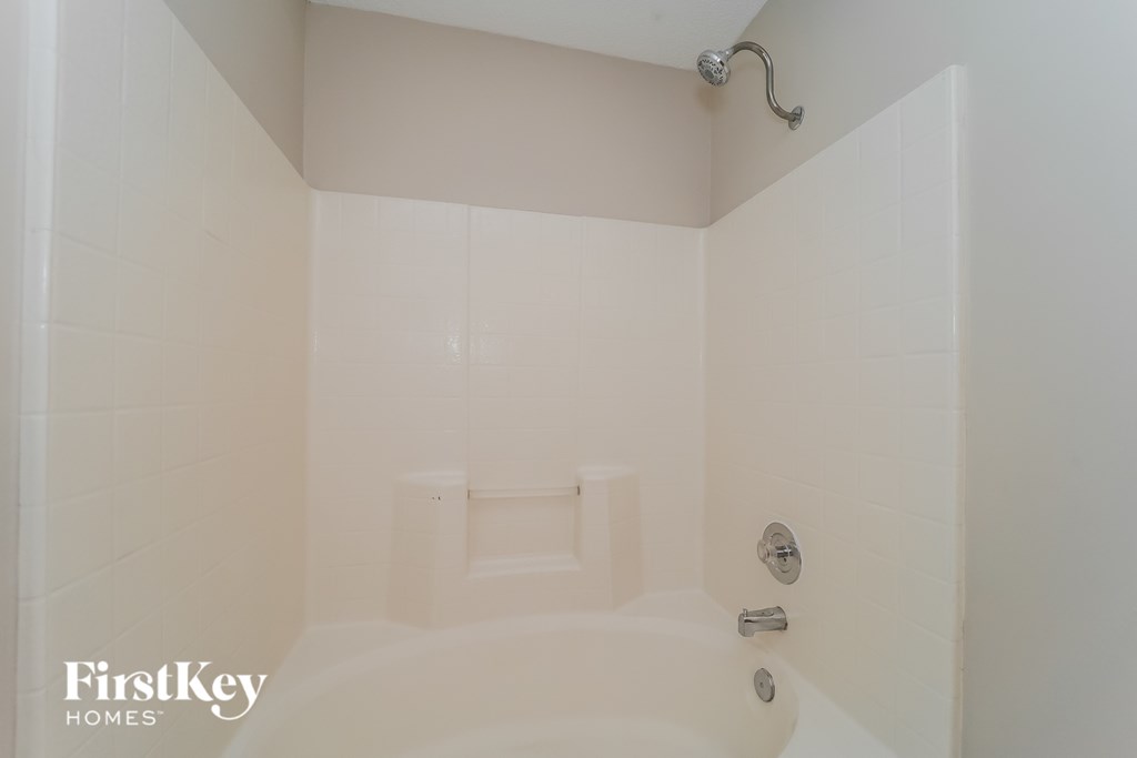 a white bathroom with a tub and a shower in it