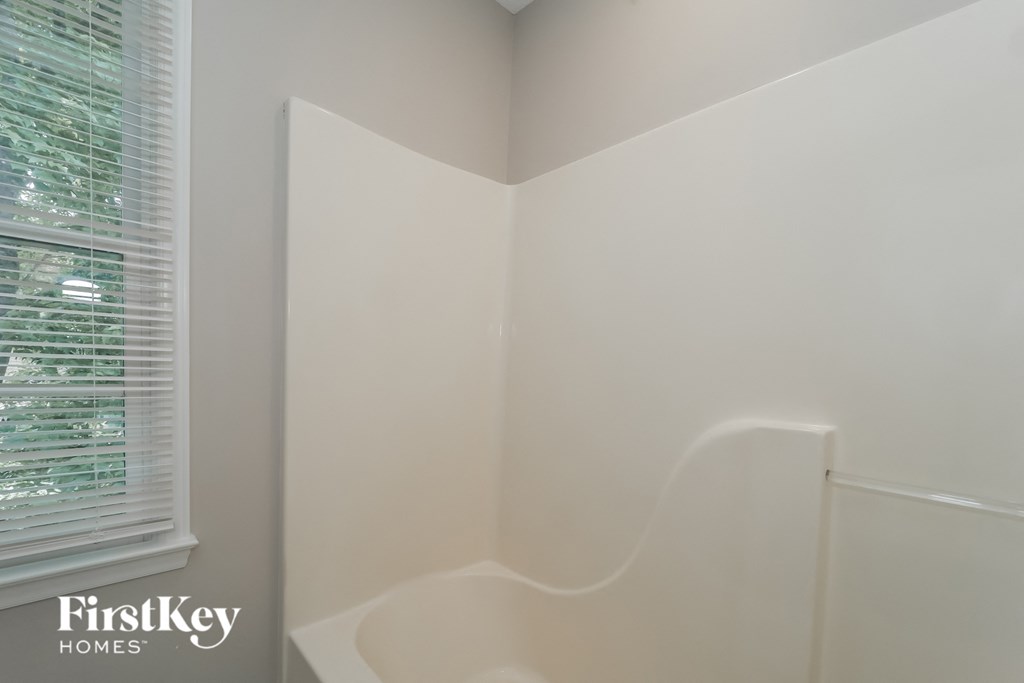 a small bathroom with a tub and a window