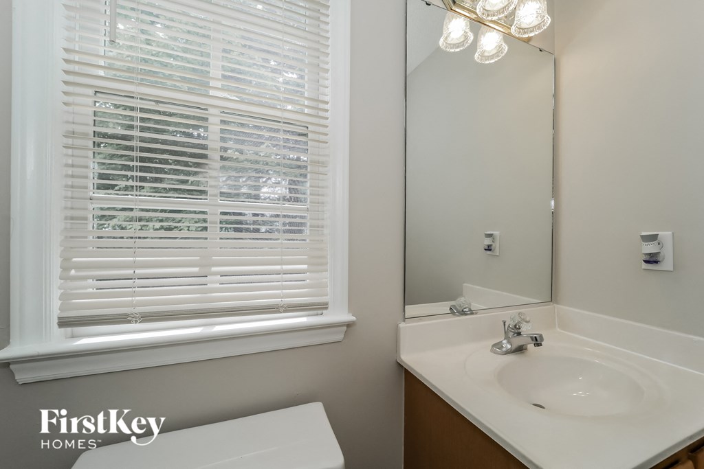 a bathroom with a sink and a mirror and a window