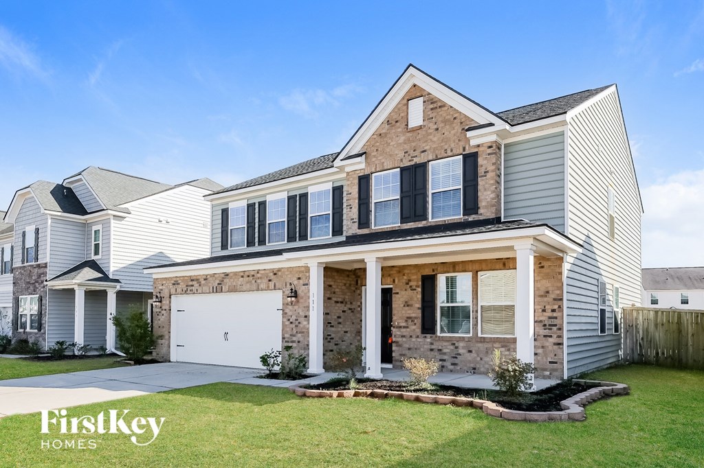 a house with a garage door in front of a grass yard