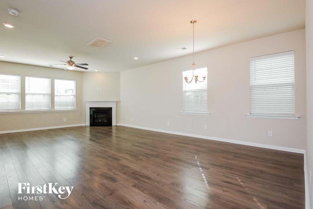 an empty living room with wood floors and a fireplace