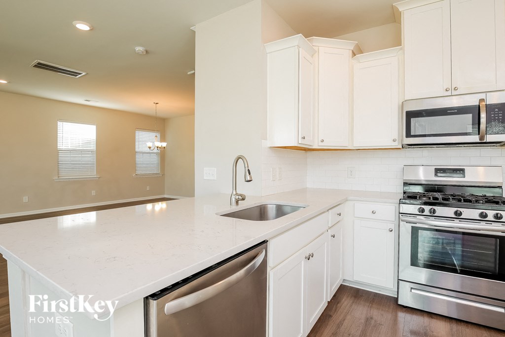 a kitchen with white cabinets and stainless steel appliances
