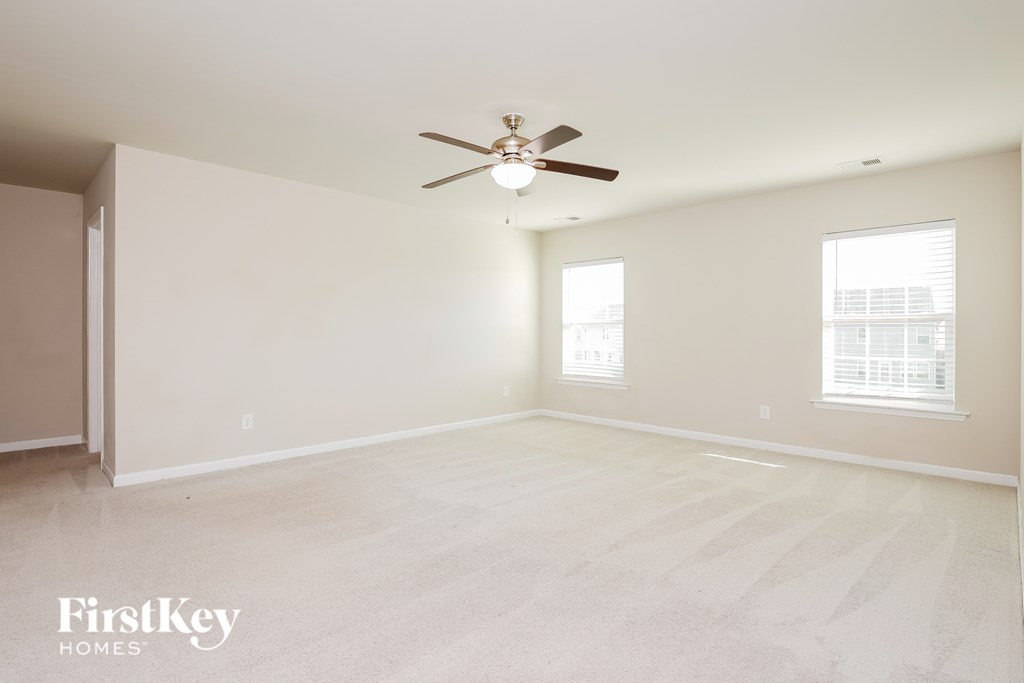 a clean and empty living room with a ceiling fan