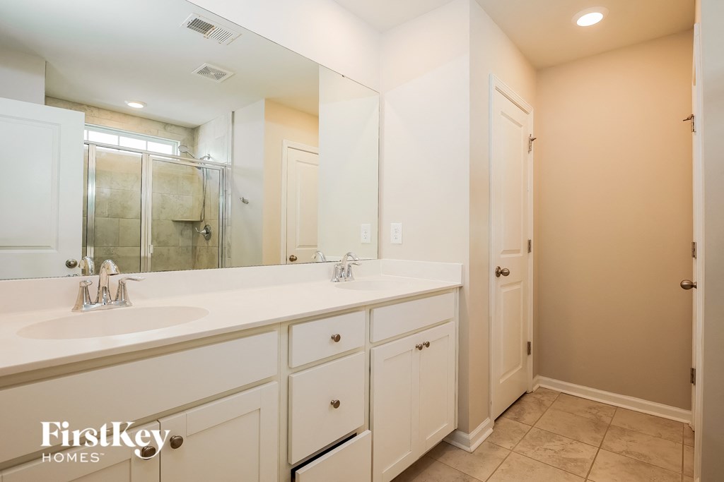 a bathroom with a large mirror and a sink and a shower