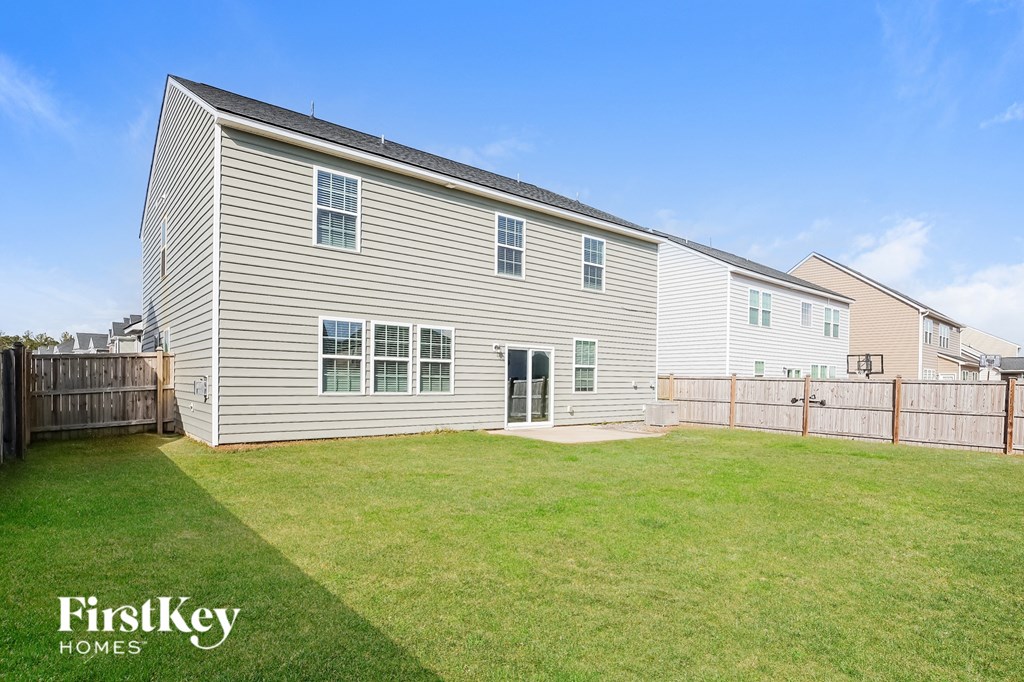 the backyard of a house with a lawn and a fence