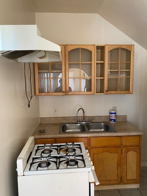 A kitchen with a white stove and wooden cabinets.
