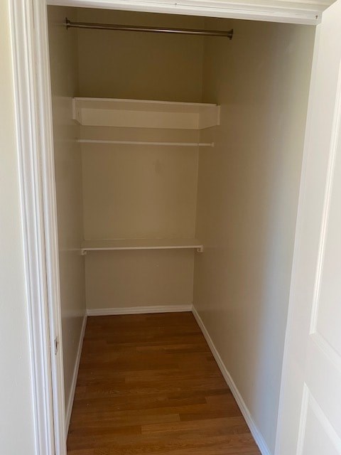 A white closet with a shelf and a door.