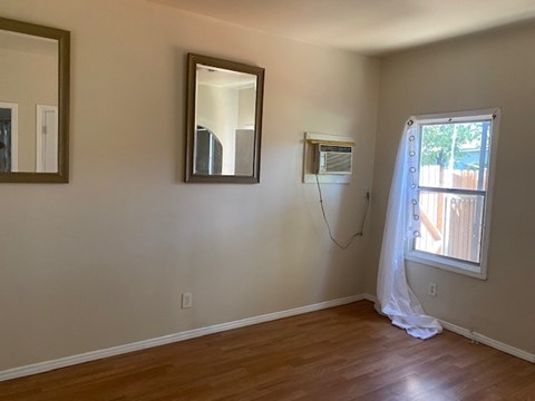 A room with a window and a curtain.