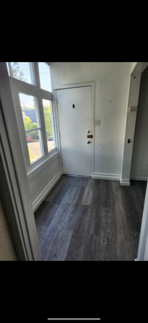 A white door is in a room with a wooden floor.