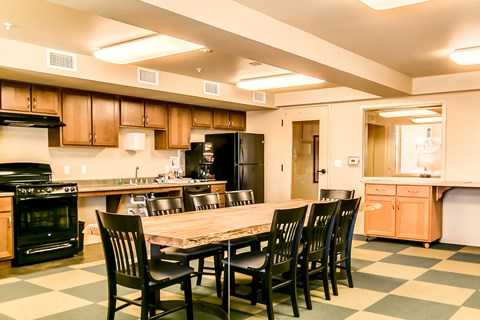 A kitchen with a checkered floor and a table with chairs.