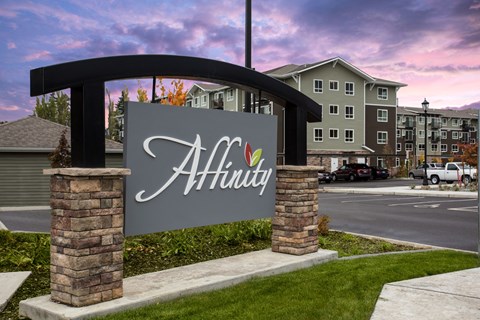 A sign that says "AHinity" in front of a building.