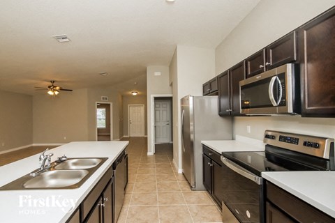 A kitchen with a sink, stove, and refrigerator.