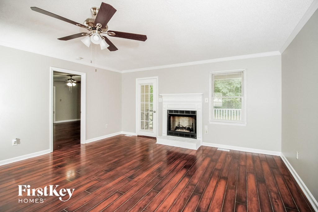 A room with a wood floor and a fireplace.
