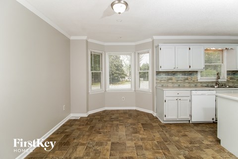 A kitchen with a tile floor and white cabinets.