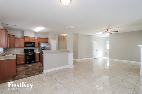 A kitchen with brown cabinets and a tiled floor.