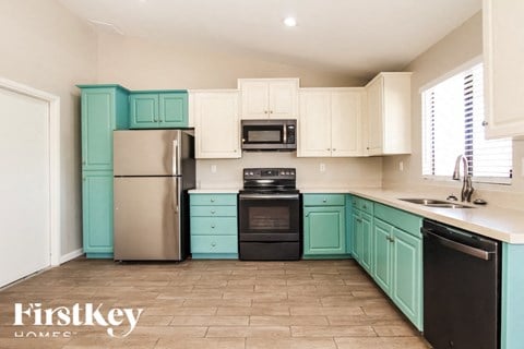 A kitchen with a black dishwasher and black oven.