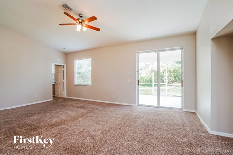 a living room with carpet and a ceiling fan