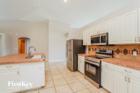 a kitchen with white cabinets and stainless steel appliances